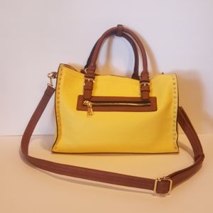 A yellow handbag with handles and strap.